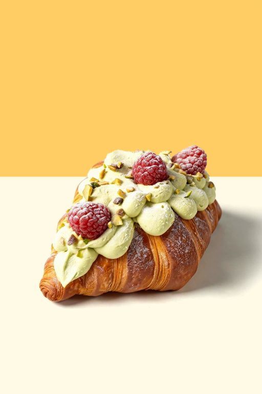 Pistachio croissant topped with raspberries