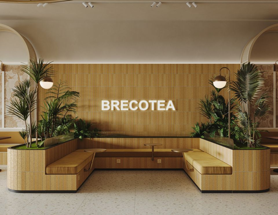 Café lounge with an oak slat wall, illuminated wordmark and palms
